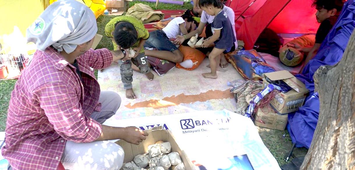 Volunteer hands out nasi bungkus