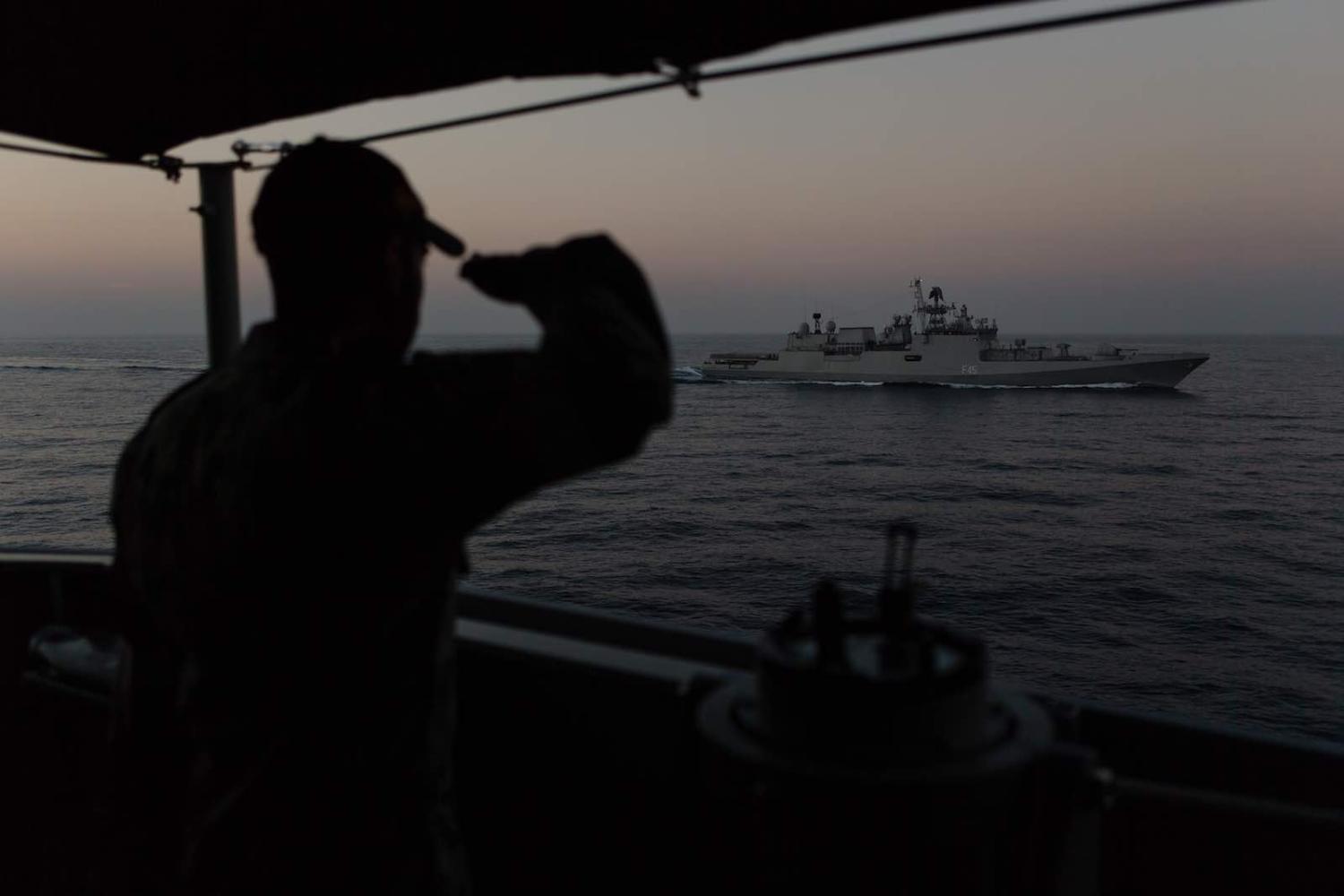 A Royal Australian Navy sailor salutes an Indian warship following an exercise in the Indian Ocean (Photo: Defence Department)