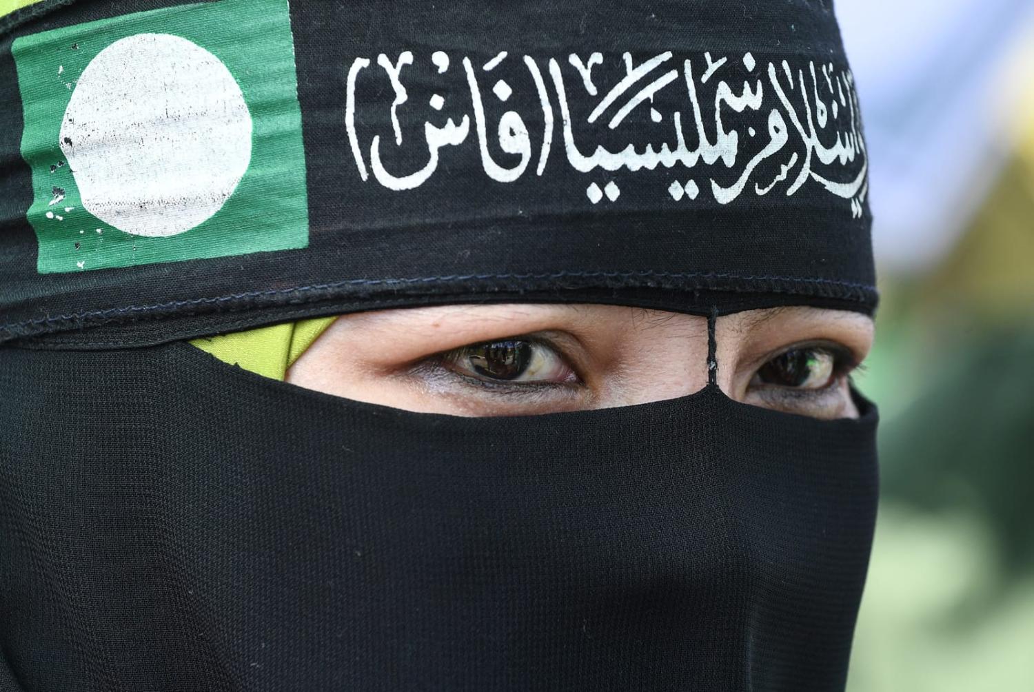 A supporter with the green flag of Parti Islam Se-Malaysia (PAS), which won a three-fold increase in the election last month, the most of any individual party, winning the most seats of any individual party (Mohd Rasfan/AFP via Getty Images)