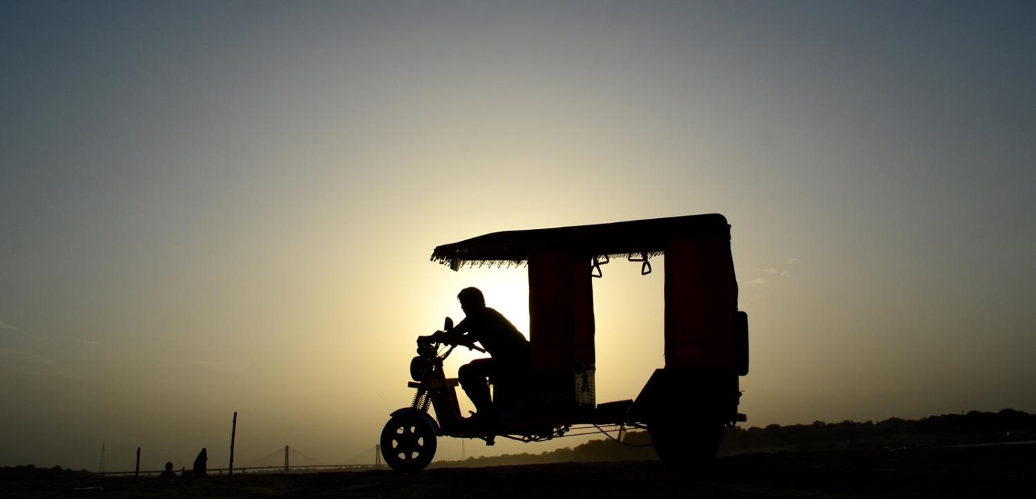 An electric rickshaw driver waits for passengers on the banks of the Ganges River (Ritesh Shukla/NurPhoto via Getty Images)