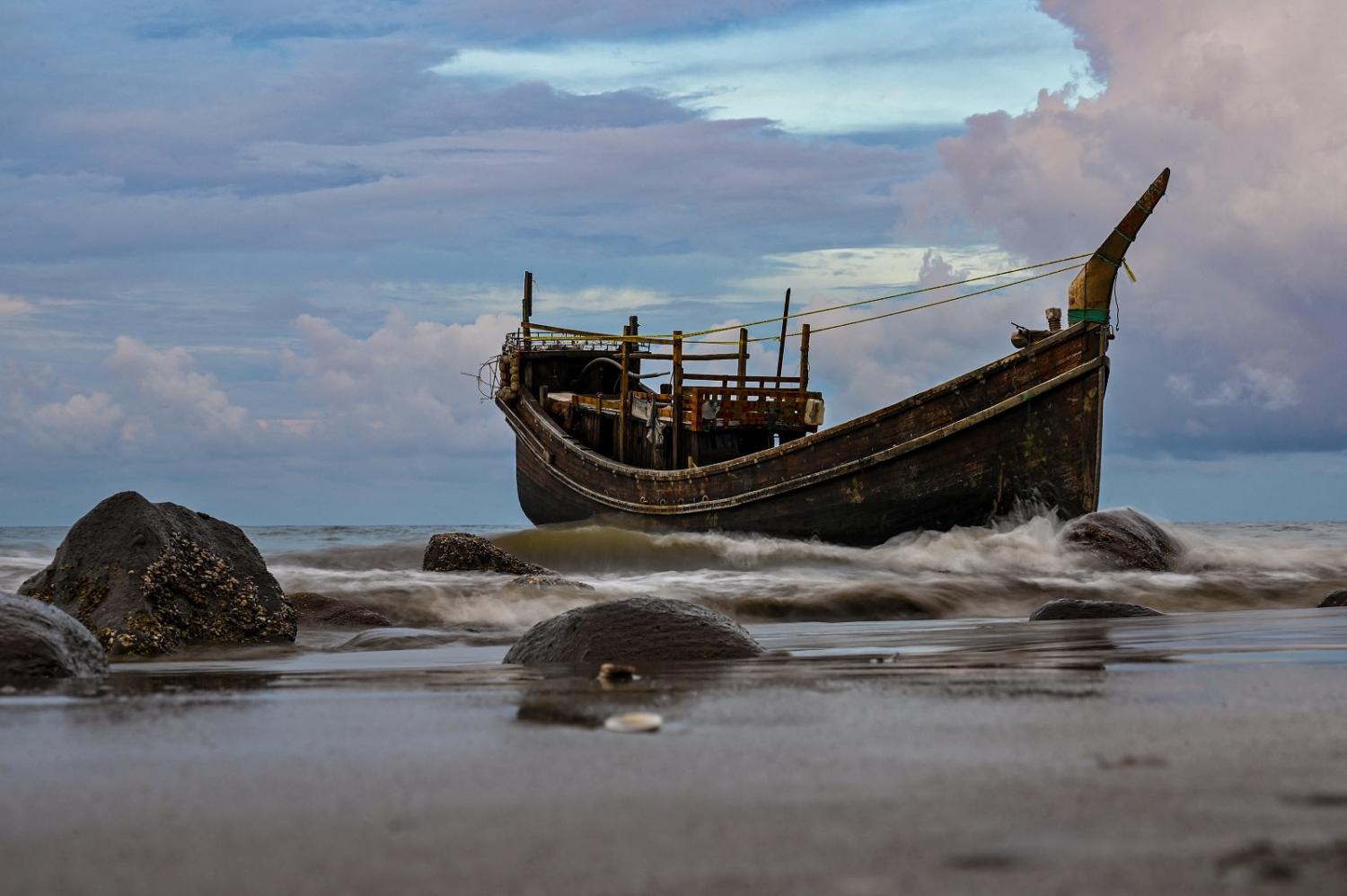 Waves lash a boat that carried Rohingya refugees to the Pidie district of Aceh province, Indonesia, 10 December 2023 (Chaideer Mahyuddin/AFP via Getty Images)