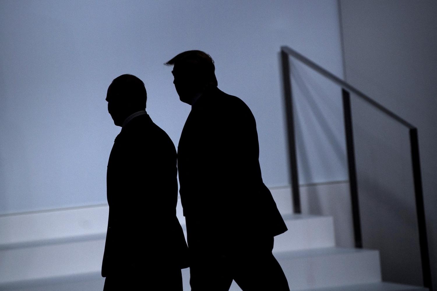 Russian President Vladimir Putin, left, and then US President Donald Trump arrive at the G20 Summit in Osaka, 28 June 2019 (Brendan Smialowski/AFP via Getty Images)