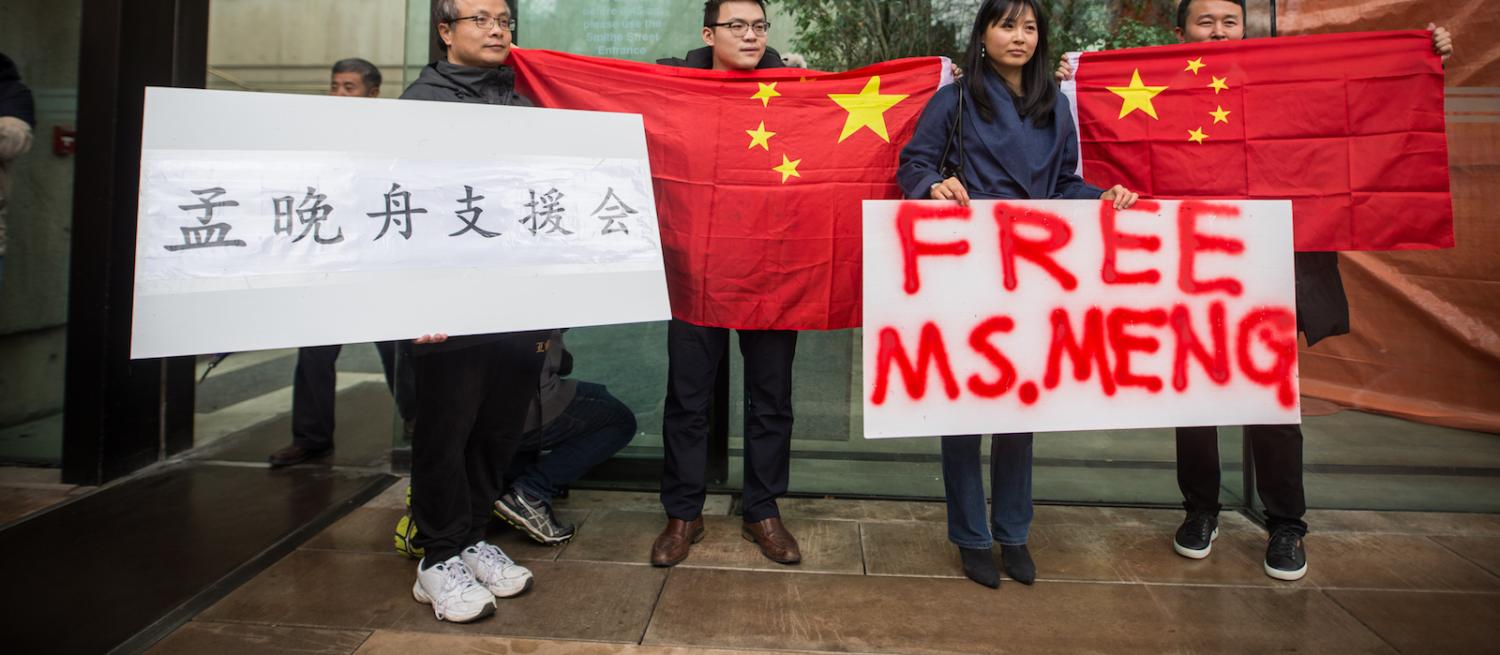 People hold signs and Chinese flags in support Meng Wanzhou outside the Supreme Court in Vancouver. (Photo: James MacDonald via Getty)