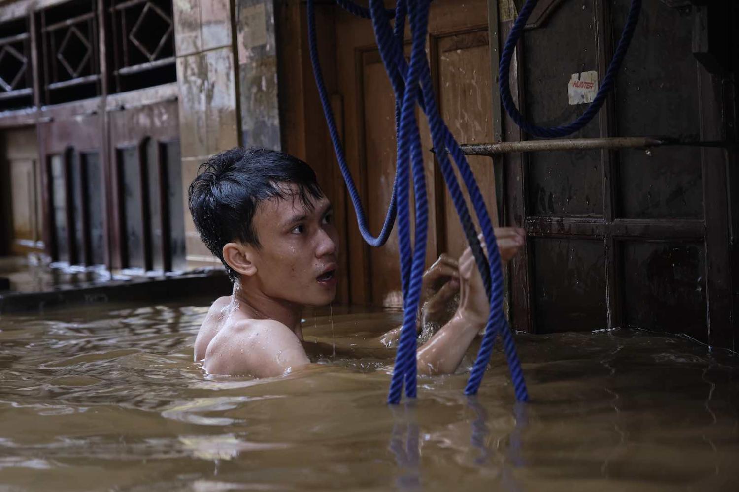 A man tries to access his house in a flooded neighbourhood in Jakarta, 2 January (Photo: Ed Wray/Getty Images)