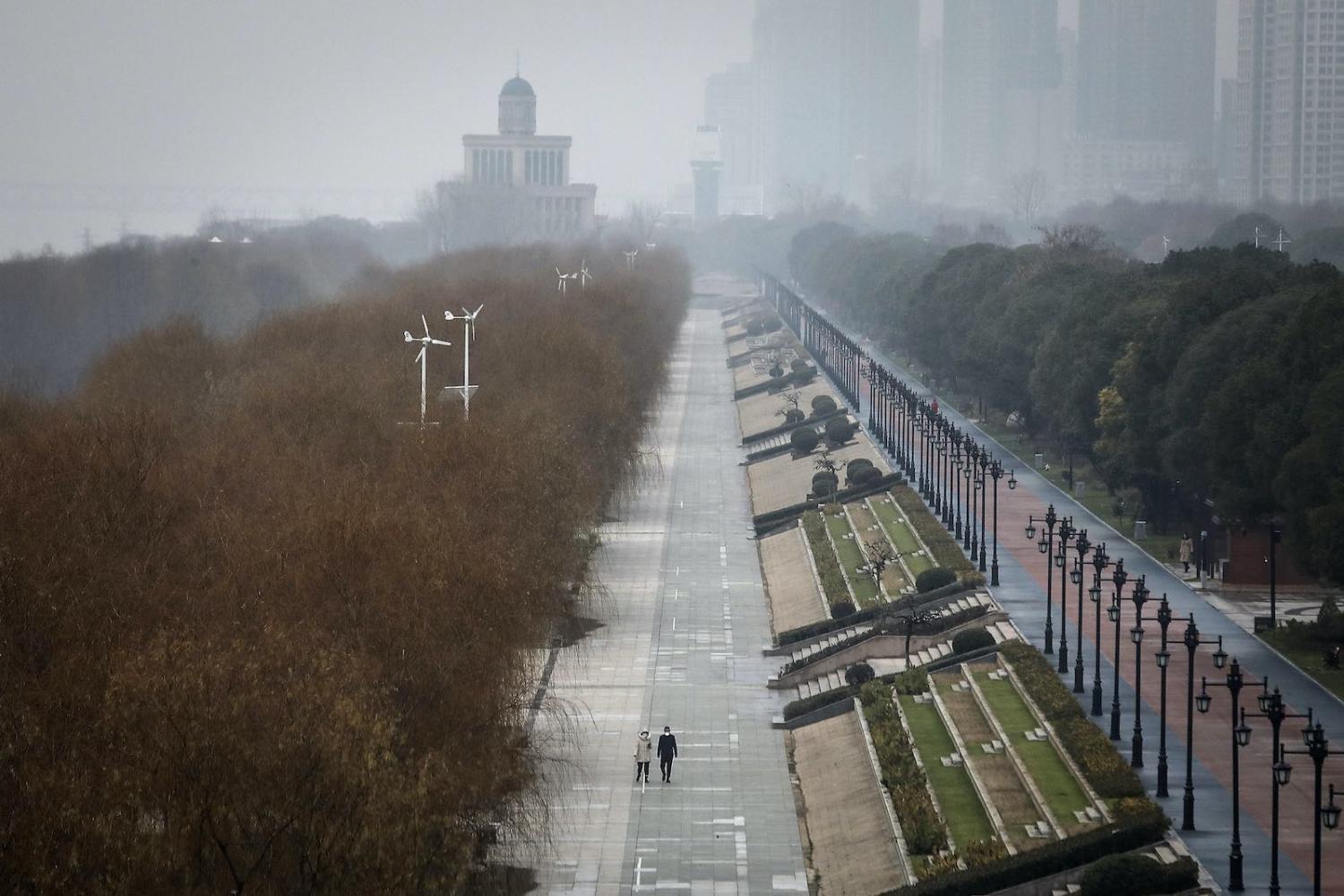Two residents walk in an empty park in Wuhan, China, 27 January 2020 (Getty Images)