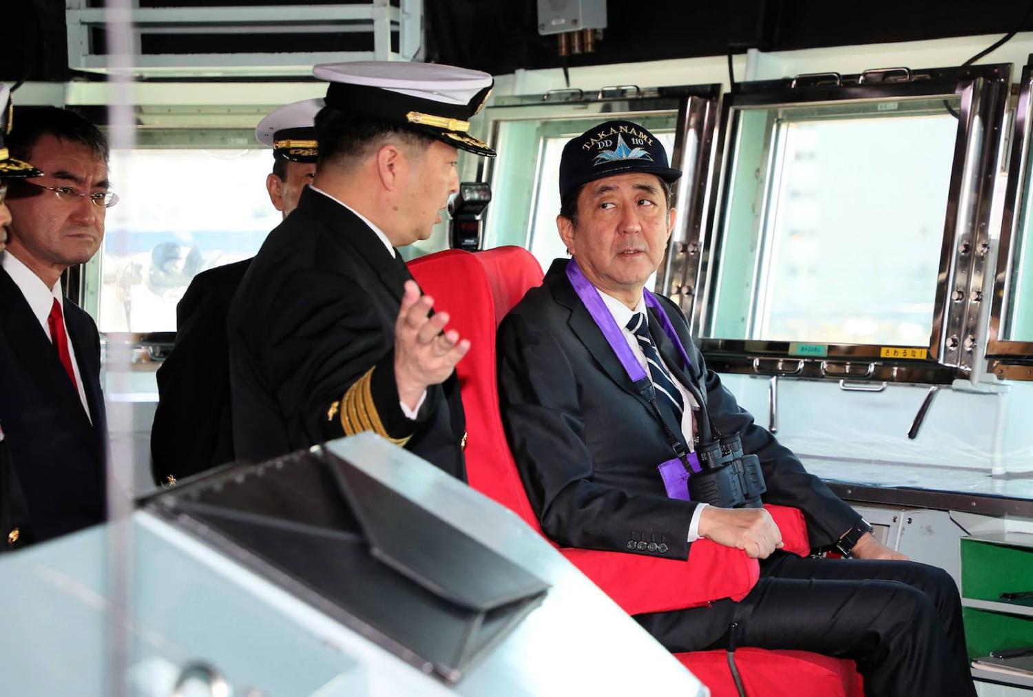 Japan’s Abe Shinzo inspects the destroyer Takanami this month before the ship deployed to the Middle East (STR/AFP/Getty Images)