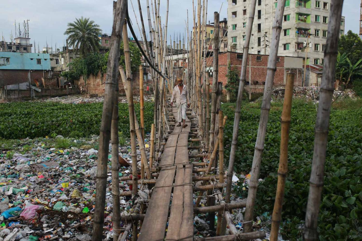 A man walks on a bamboo bridge in Keraniganj, near Dhaka, Bangladesh, September 2020 (Rehman Asad/NurPhoto via Getty Images)