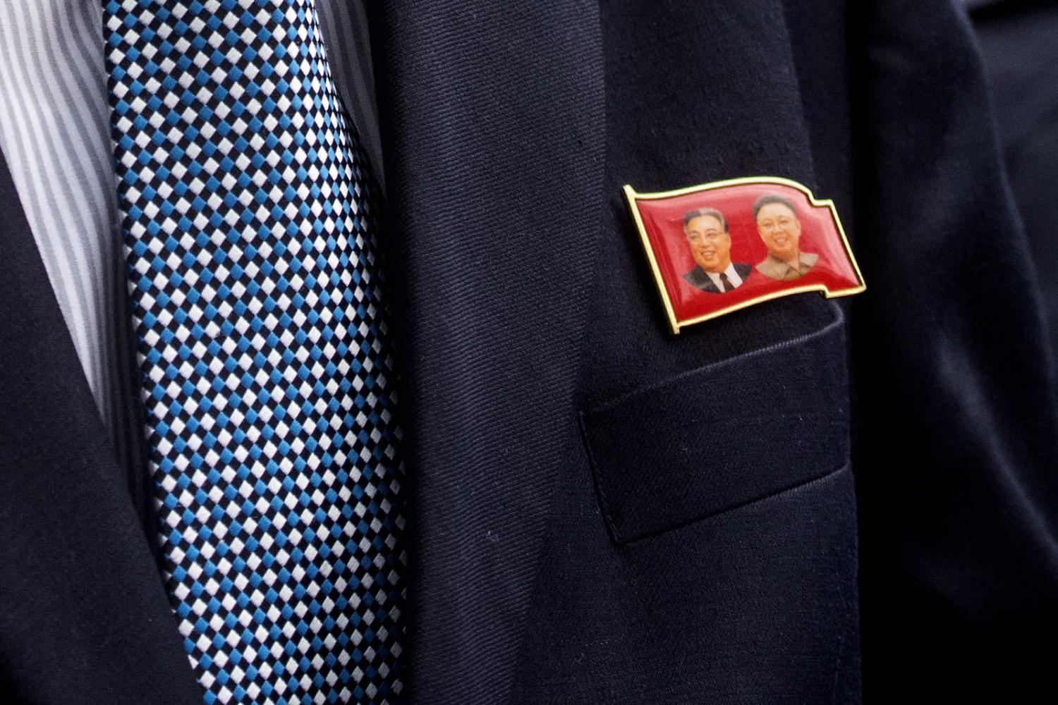 A North Korean diplomat wears a badge depicting former leaders Kim Il Sung and Kim Jong Il (Vivian Lo via Getty Images)