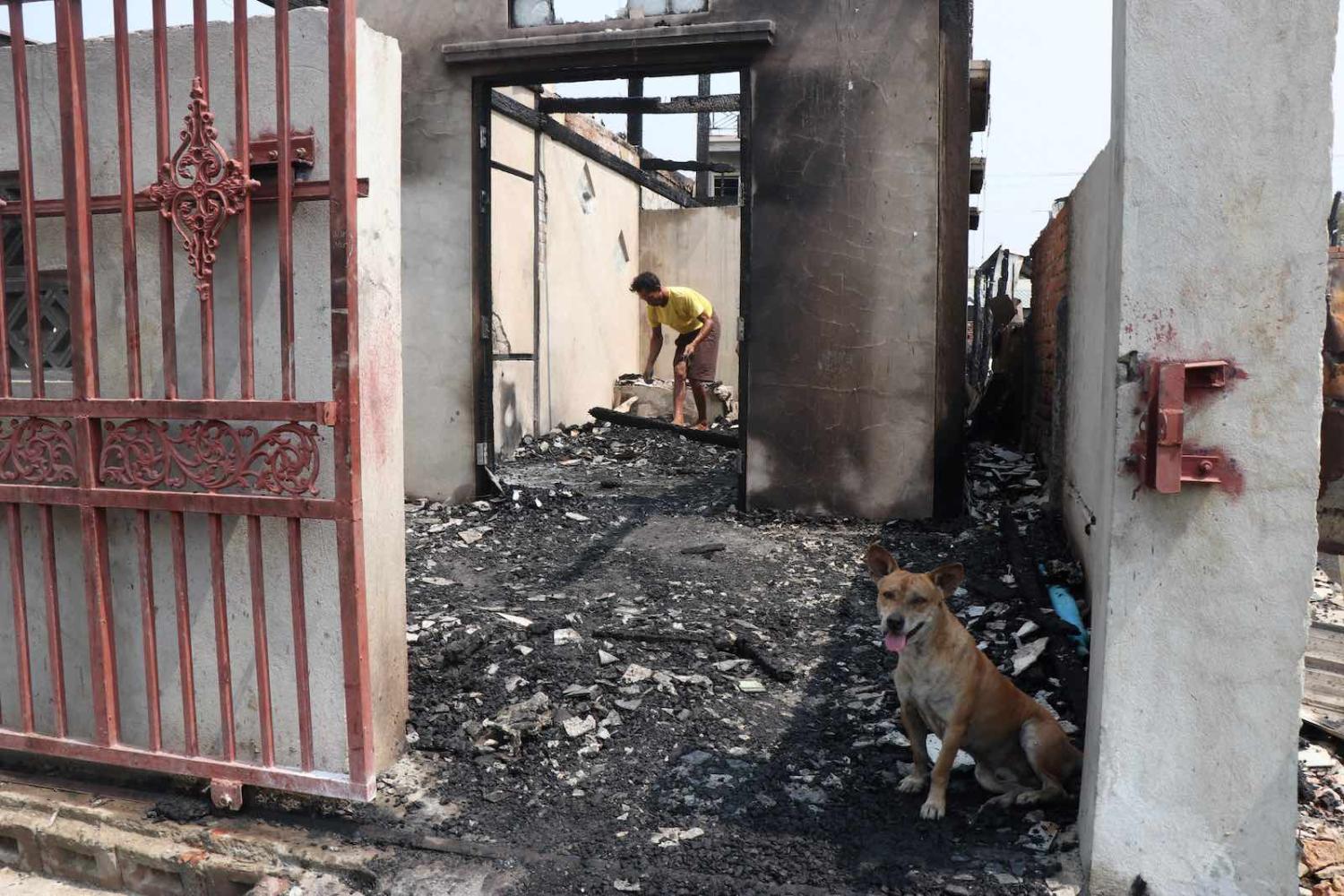Inspecting the aftermath of a fire that engulfed over 100 houses in Mandalay, Myanmar, 1 April 2021 (Stringer/AFP via Getty Images)