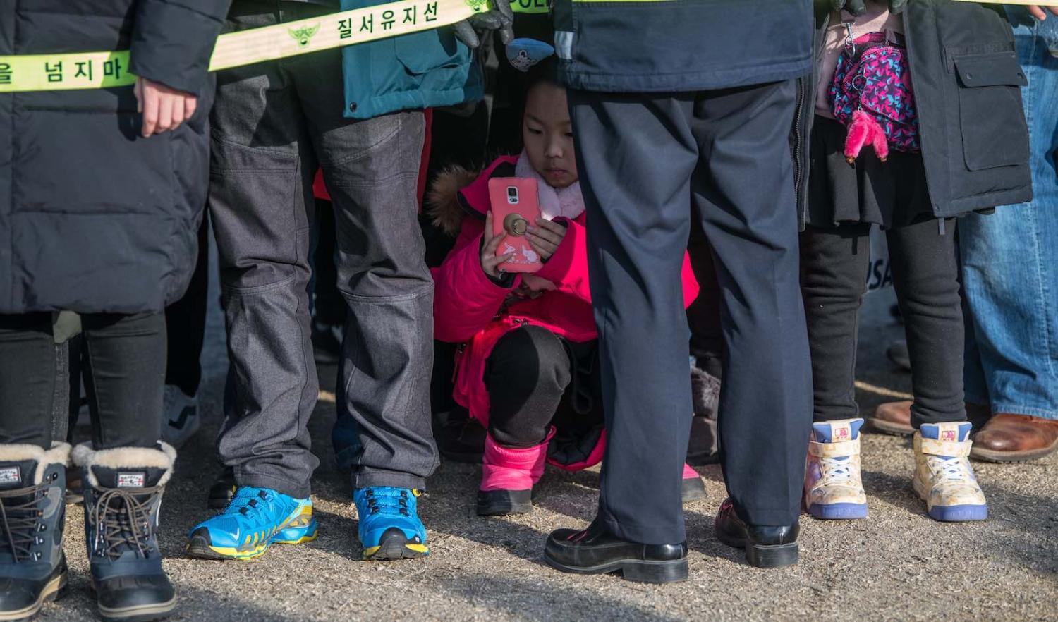 A girl crouches for a photograph during South Korea’s PyeongChang Winter Olympics in February (Photo: Carl Court/Getty)